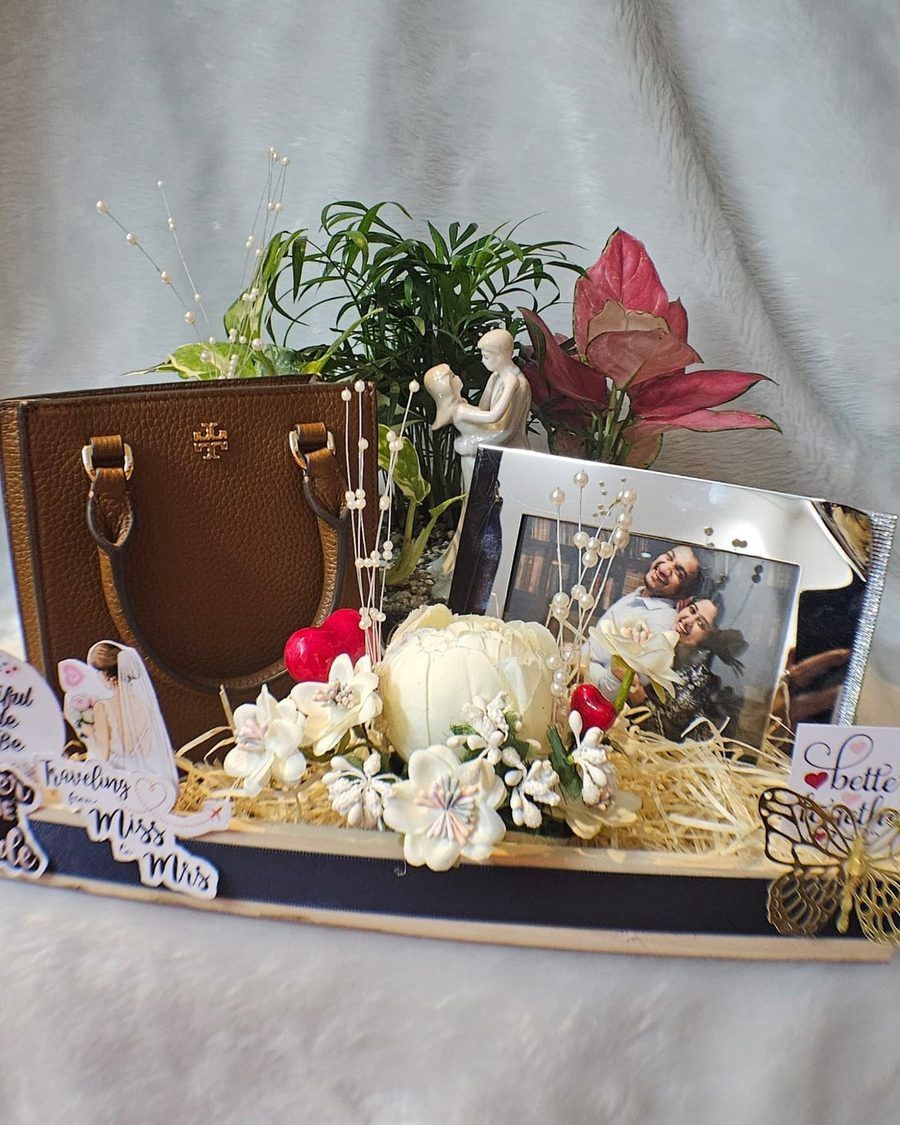 A planted arrangement built around framed photographs and keepsakes.